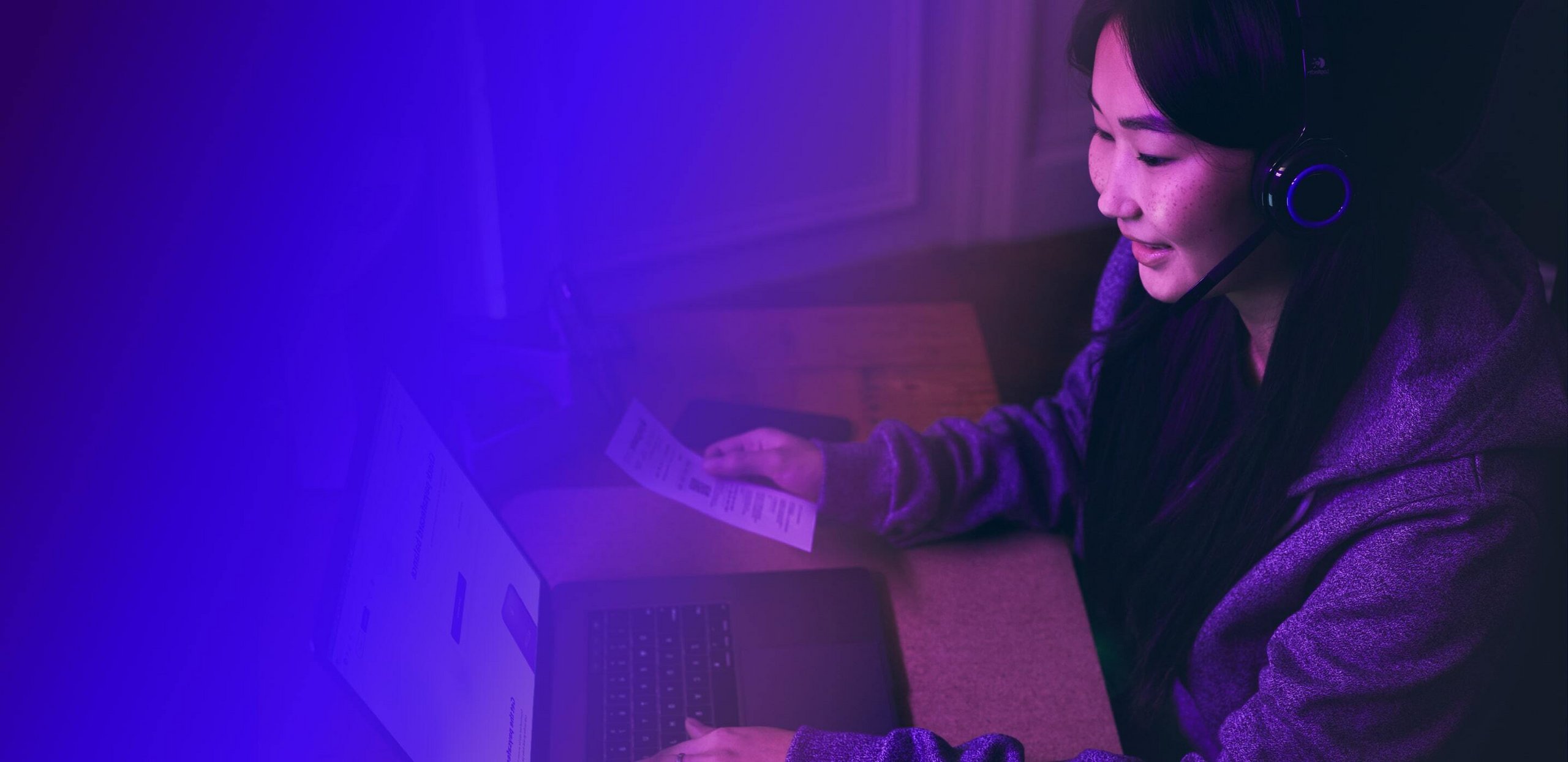 Une femme à l’ordinateur paye en toute sécurité en ligne avec paysafecard.