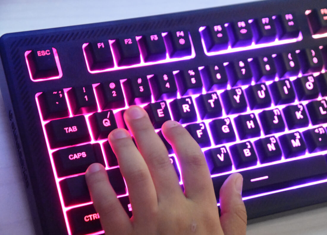 child's hand on glowing keyboard