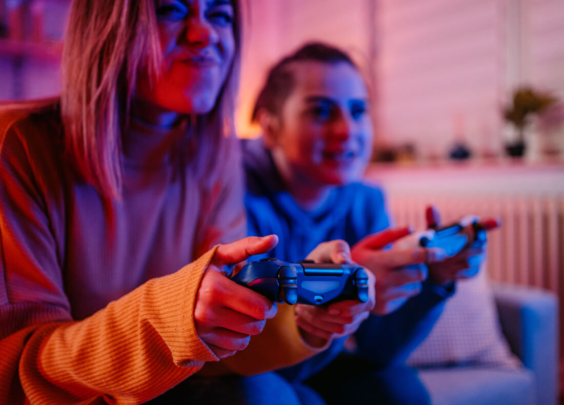 Two women playing a video game and using their controllers