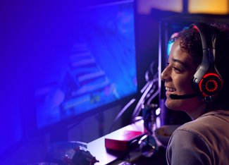someone with a headset playing a game on a computer