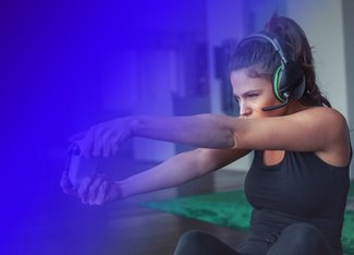 Woman with a pair of headphones is focused on playing a video game